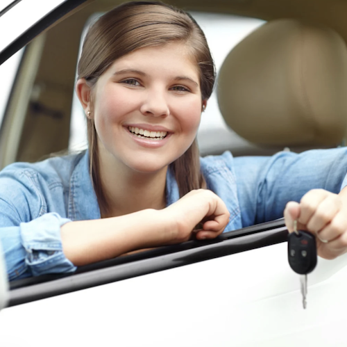 Girl sitting in the driver's seat of a car holding keys