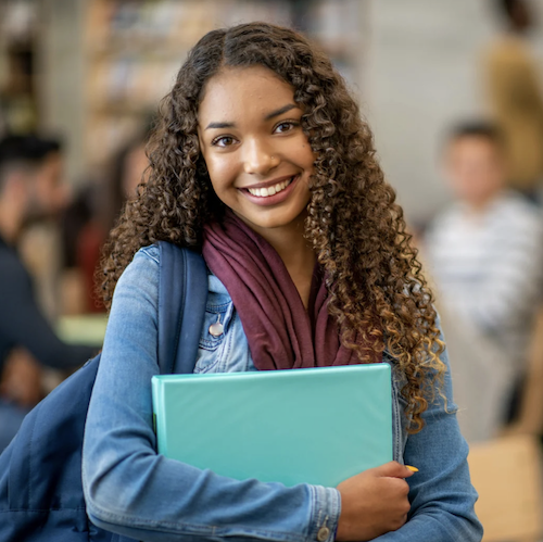 Teenage girl holding folder in classroom